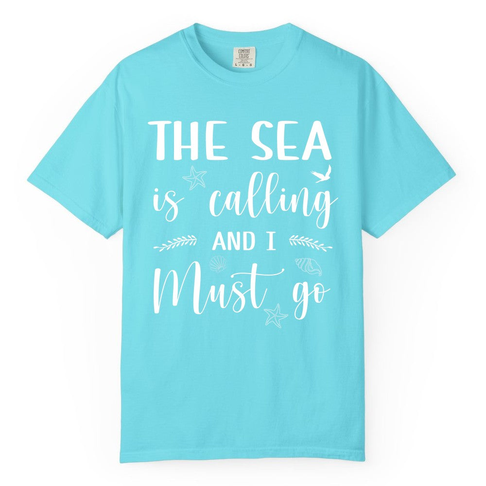 The Sea Is Calling Shirt - Ocean Lover Apparel Beach Vacation Tee (Comfort Color) in Lagoon Blue - The Sea Is Calling Shirt - Ocean Typography With Shells and Starfish